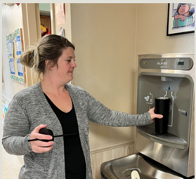 woman filling up a water bottle at a water bottle filling station