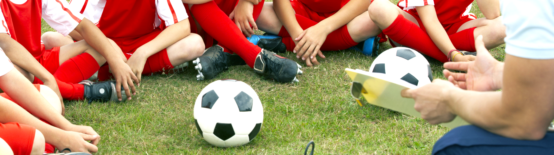 children sitting around soccer ball