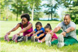 photo of 3 people stretching sitting on the grass