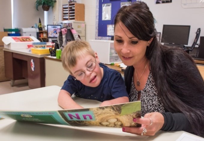 Teacher and student reading a book