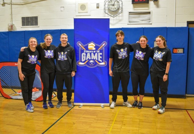 "Northtowns Academy students stand in front of a Student of the Game program banner" 